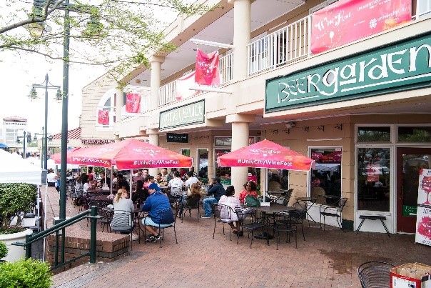 A group of people sitting outside a restaurantDescription automatically generated with medium confidence