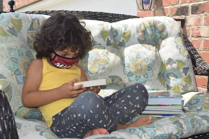 A child reads books from Charlotte Mecklenburg Library at home.