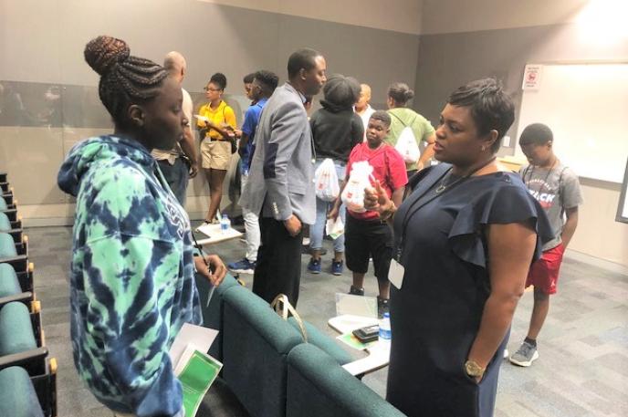 A Charlotte Mecklenburg student engages in conversation with a careerwoman during the Library's "Bigger than High School" event in July, 2019. 