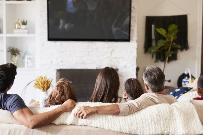 A family watches TV together.
