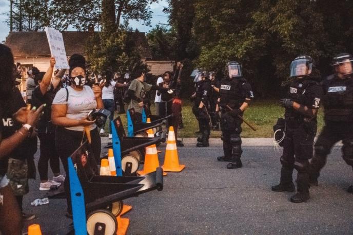 Local citizens protest the death of George Floyd by police with uniformed Charlotte Mecklenburg police officers standing watch.