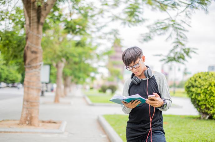 A young person reads poetry from Charlotte Mecklenburg Library on a mobile device.
